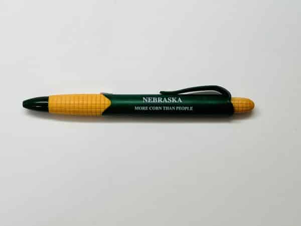 Green ballpoint pen in the image of an ear of corn with the saying "Nebraska, more corn than people."
